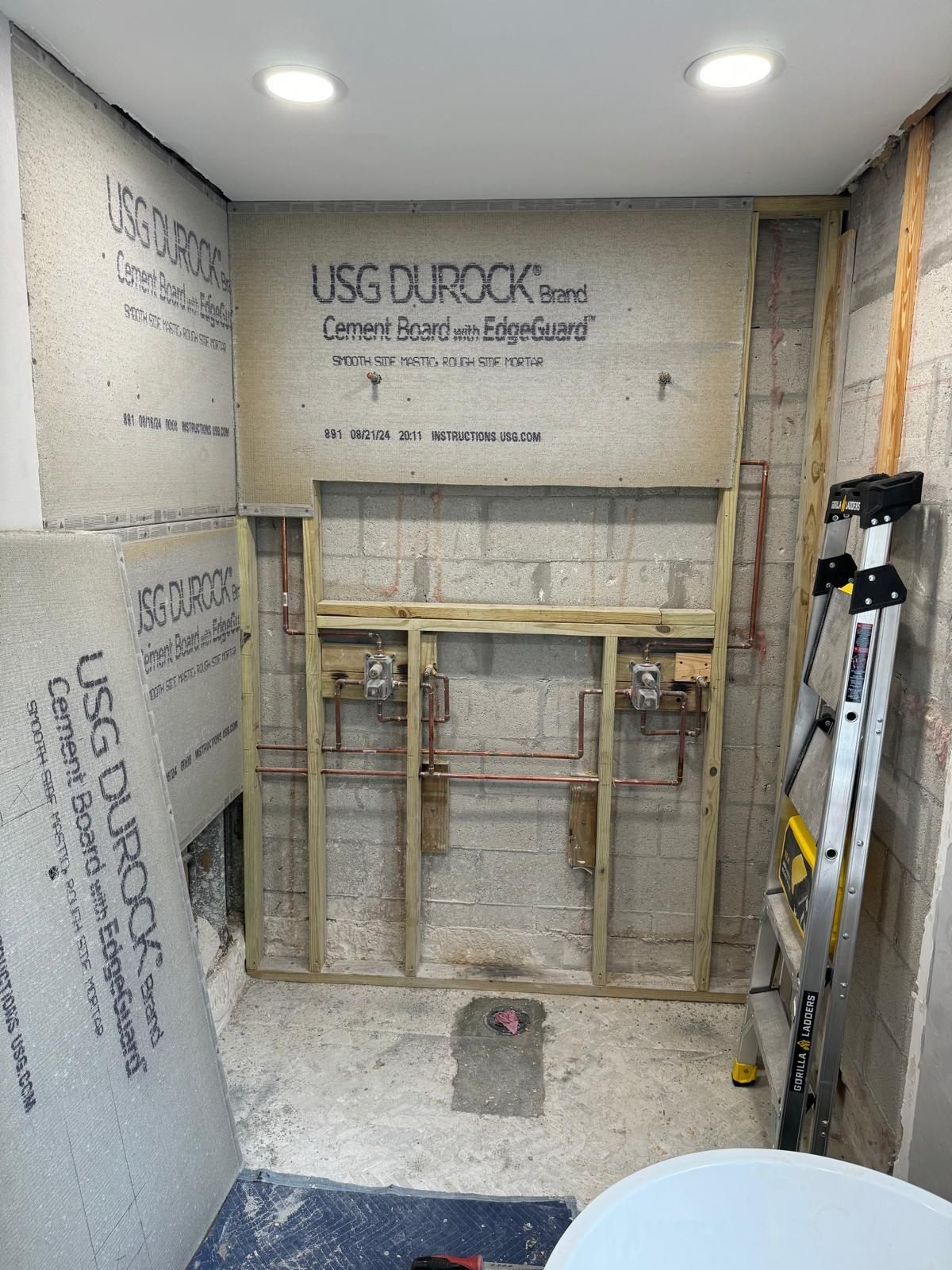 Plomería de la ducha en obra, con tubería de cobre y cement board instalado