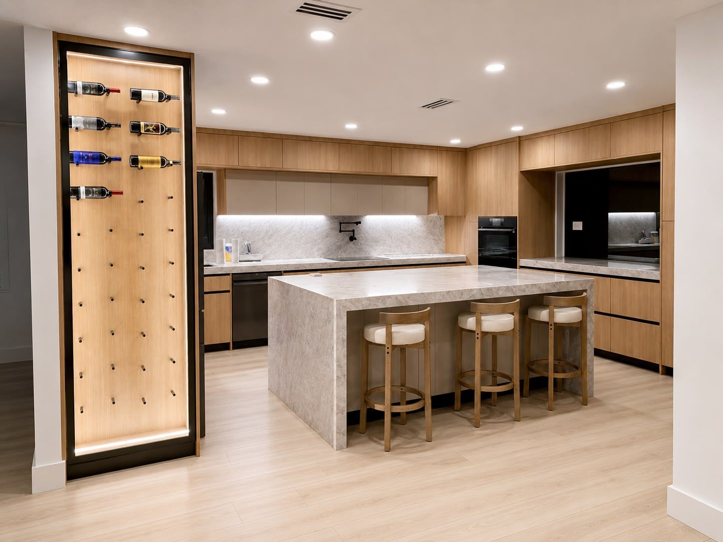Cocina de lujo con isla de mármol, gabinetes de madera clara y bodega de vinos iluminada