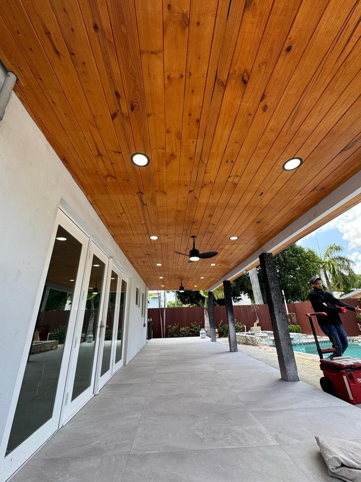 Terraza con techo de madera barnizada, luces empotradas y piso de porcelanato